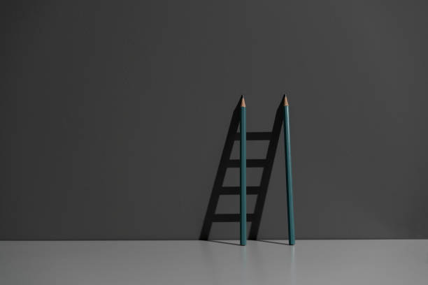 istock pencil leaned on the wall and creating ladder made of shadow 1423794176