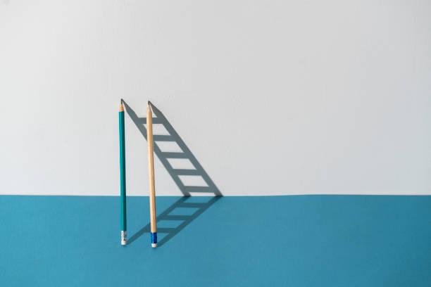 istock pencil leaned on the wall and creating ladder made of shadow 1423794192