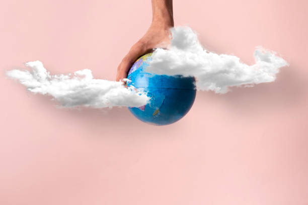 istock human hands hold planet earth high in the sky with clouds, creative concept 1423795158