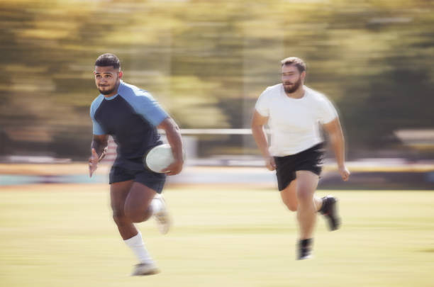 istock Mixed race rugby player running away from an opponent while attempting to score a try during a rugby match outside on a field. Hispanic male athlete making a play to try and win the game for his team 1423804162
