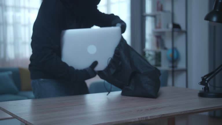 Close Up Of A Thief Man Holding Flashlight Stealing Wallet, Smartphone, And Laptop In Someone'S House Before Walking Away