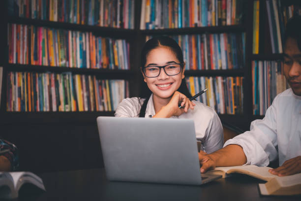 gruppe der vielfalt student spricht und lacht zusammen am asian college, arbeitet an laptop und smartphone. glücklicher multiethnischer freund schließt erfolgreich den abschlussbericht ab und besteht die abschlussprüfung - computer student mixed race person multi ethnic group stock-fotos und bilder