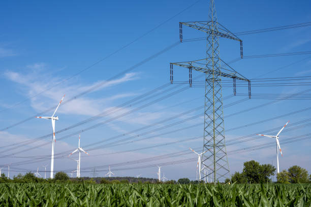Electricity pylons, power lines and wind turbines stock photo
