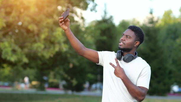 istock African American man makes selfies on smartphone in park 1423820046