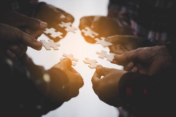 istock Hands holding piece of blank jigsaw puzzle for teamwork 1423821567