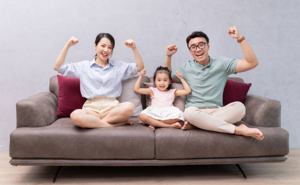 istock Young Asian family sitting on sofa 1423826905