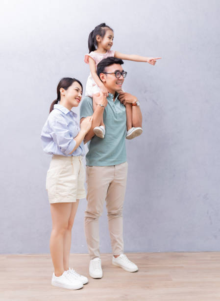 배경에 서있는 젊은 아시아 가족 - photography vertical color image studio shot 뉴스 사진 이미지