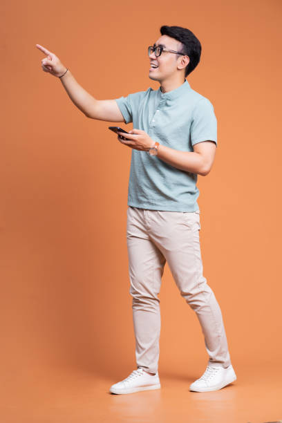 bild eines jungen asiatischen mannes, der auf dem rücken steht - one person happiness pointing full length stock-fotos und bilder