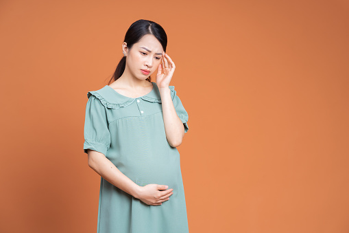 Photo of Asian pregnant woman on background