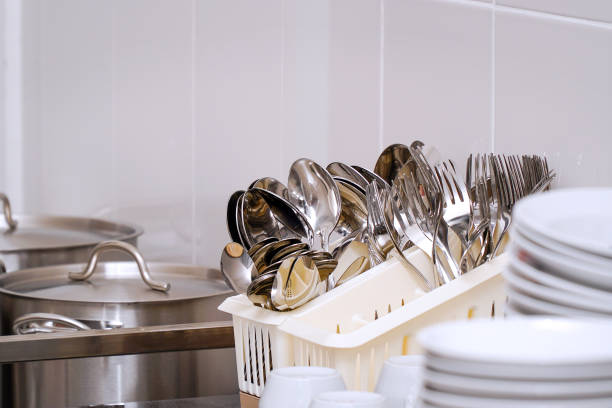 Clean spoons and forks in a stand on the table