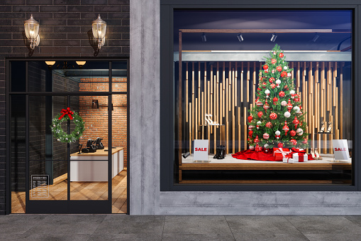 Christmas Sale On Store. Exterior Of Store With Christmas Tree, Ornaments And Gift Boxes Displaying In Showcase