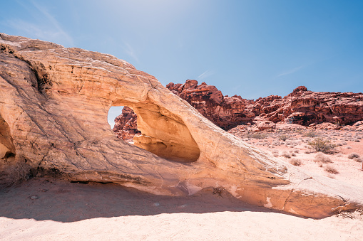 A natural arch seen in Valley of Fire during a hot day in the hot desert landscape in Nevada, USA.