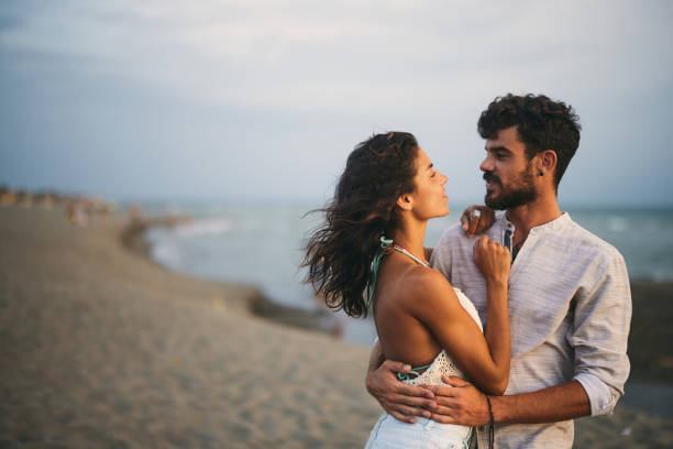 istock Young smiling couple talking on the beach. 1423842525
