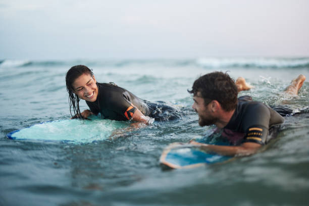 istock Happy couple talking on surfboards at sea. 1423844247