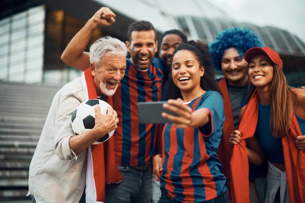 istock Cheerful soccer fans having fun while taking selfie with cell phone. 1423844312