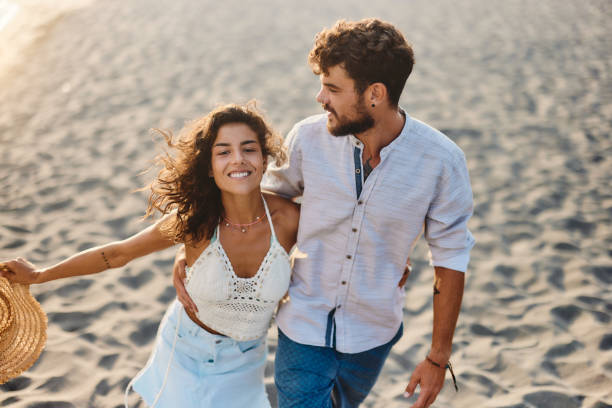 istock Happy couple enjoying in summer walk on the beach. 1423844901