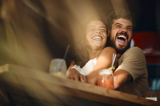 istock Below view of cheerful couple having fun in a bar. 1423844937