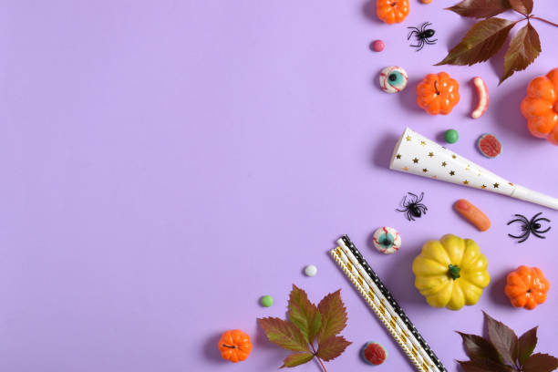 istock A mockup with Halloween decorations with pumpkins and sweets on a purple background with a place for text. A place to copy. 1423846675