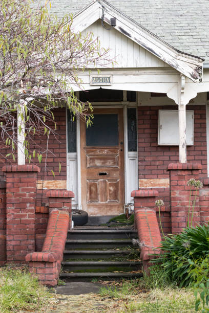 vue de face d’une vieille maison à façade en brique avec marches inclinées - front stoop photos et images de collection