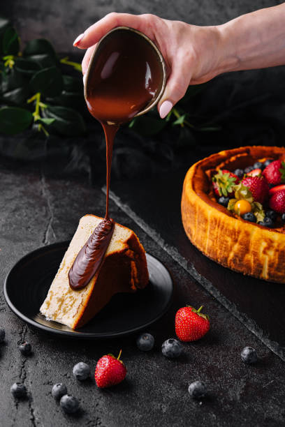 istock Pouring chocolate on delicious cheesecake and berries 1423850260