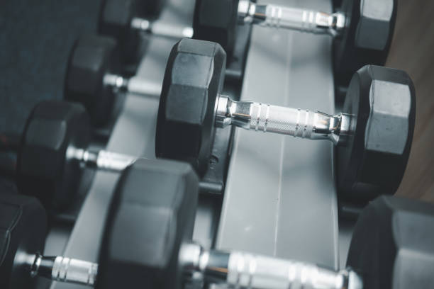 istock Rows of metal dumbbells on rack for strength training in gym 1423850418