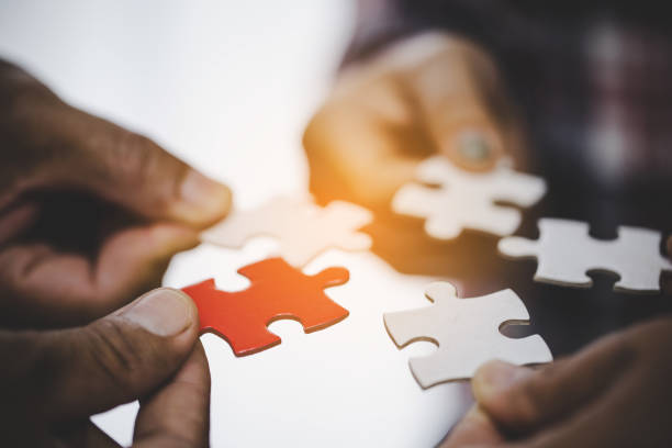 istock Hands holding piece of blank jigsaw puzzle for teamwork 1423852617