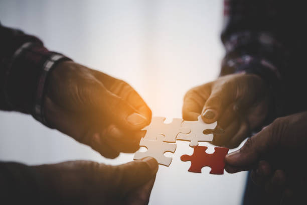 istock Hands holding piece of blank jigsaw puzzle for teamwork 1423853187