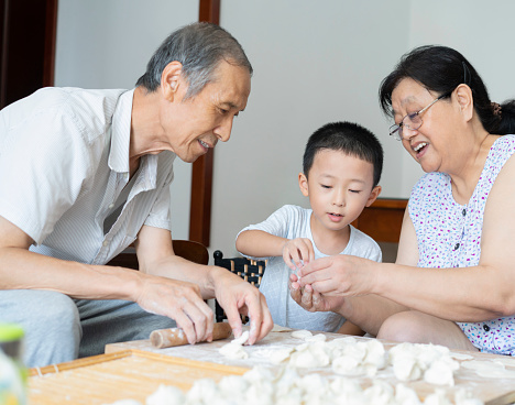 Grandparents and grandson make dumplings together