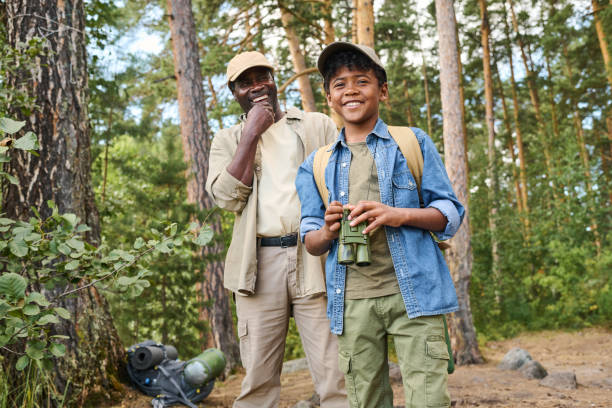 istock Two cheerful hikers with backpacks standing in pine tree forest and having fun 1423865673