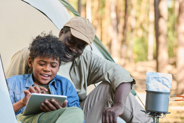 istock Happy youthful boy with tablet scrolling through online photos during trip 1423865863