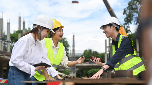 istock Engineer team in safety helmet and reflective jackets are planning development details and inspecting construction site. 1423866029