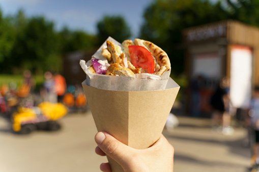 Greek street food gyros in hand. Greek and Mediterranean cuisine with meat in pita. High quality photo