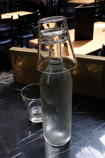 Glasses and a water bottle on a table.