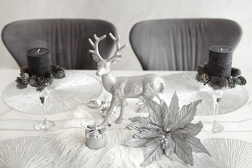 Elegant christmas table decorations in gray and silver colors for winter holidays.