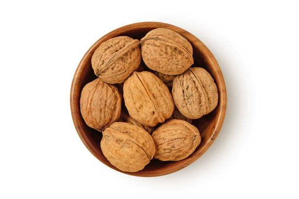 istock Shelled walnuts in wooden bowl on white background 1423872891