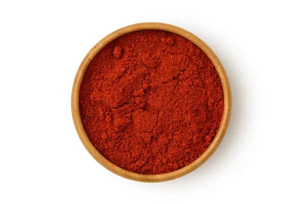 Photo of Paprika powder in wooden bowl on white background