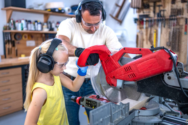 istock Father and daughter sawing plank with saw 1423874695