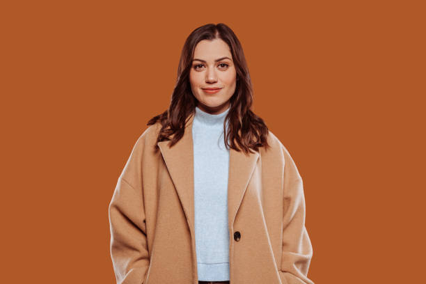 istock Beautiful smiling woman in beige coat at studio 1423874727