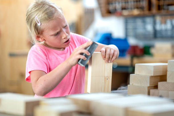 istock Girl sanding wooden blocks 1423874971