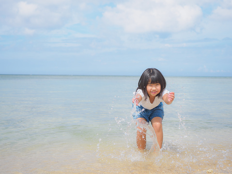 A Japanese family enjoying a holiday with their children at a beach in Okinawa, Japan.