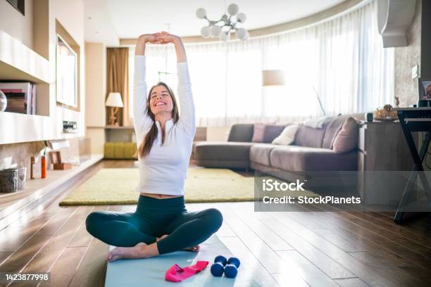 Woman Doing Stretching Exercise At Home Stock Photo - Download Image Now - Exercising, Healthy Lifestyle, Sport