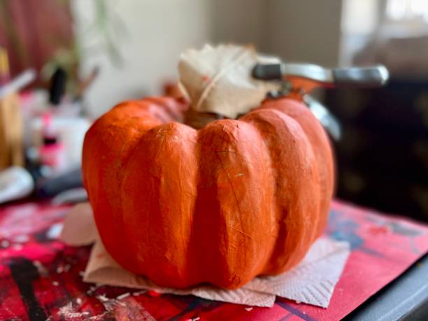 istock Papier Mache Pumpkin Painting in Progress with Clamp 1423879129
