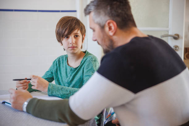 istock Preadolescent boy sitting at home and talking to his caretaker 1423881839