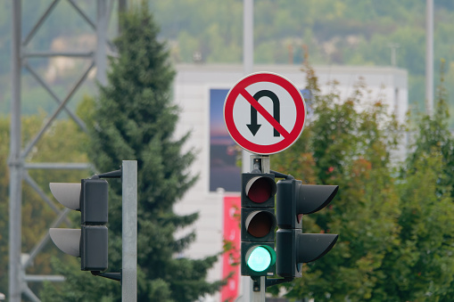 No U-Turn Sign and a traffic light attached to a metal pole