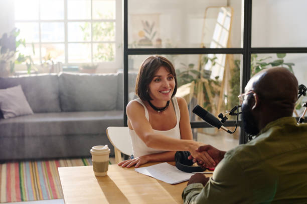 istock Young smiling woman greeting black man by handshake over desk with document 1423887753