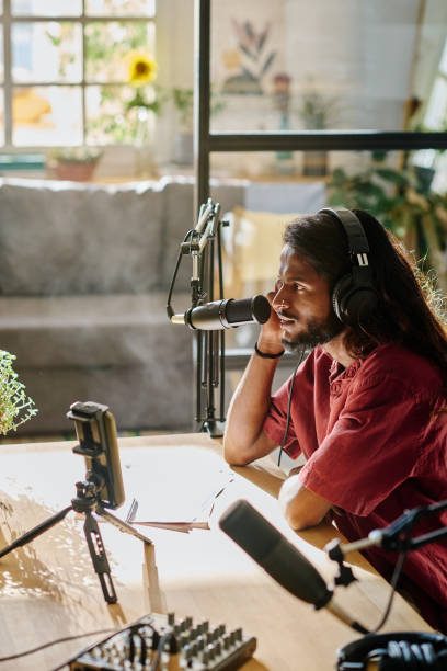 istock Side view of young sersious male host or blogger talking in microphone 1423887953