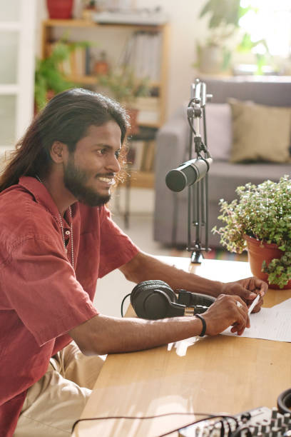 istock Young smiling man with dark long hair communicating with guest in studio 1423888599