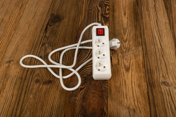 istock Power Strip, Extension Cable on Wooden Floor Background 1423889804