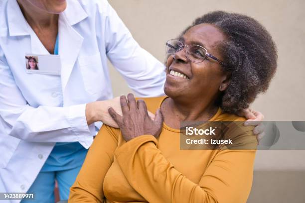 Healthcare Worker Talking With Senior Woman Stock Photo - Download Image Now - 70-79 Years, Adult, Adults Only