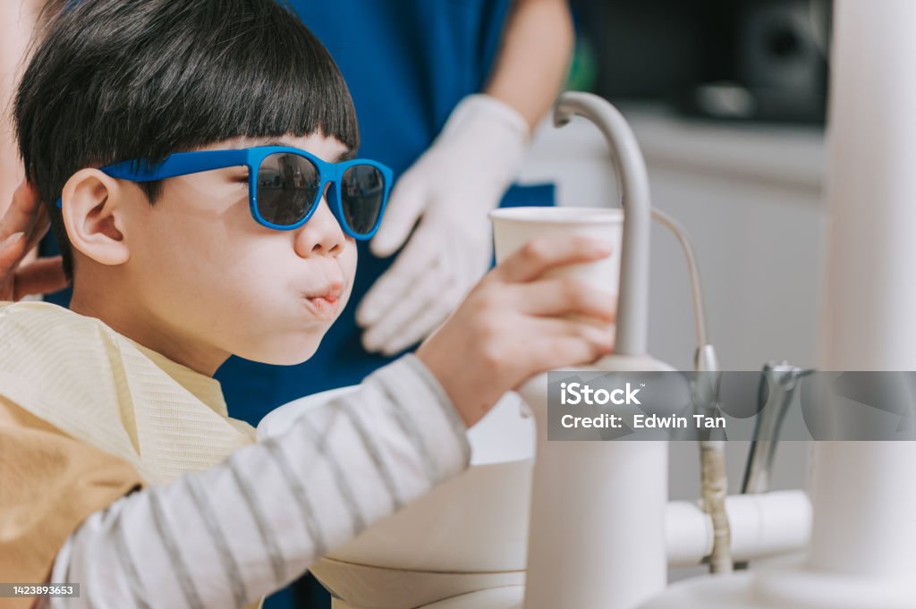 Asian chinese Dental young patient washing out his mouth Dental Equipment Stock Photo